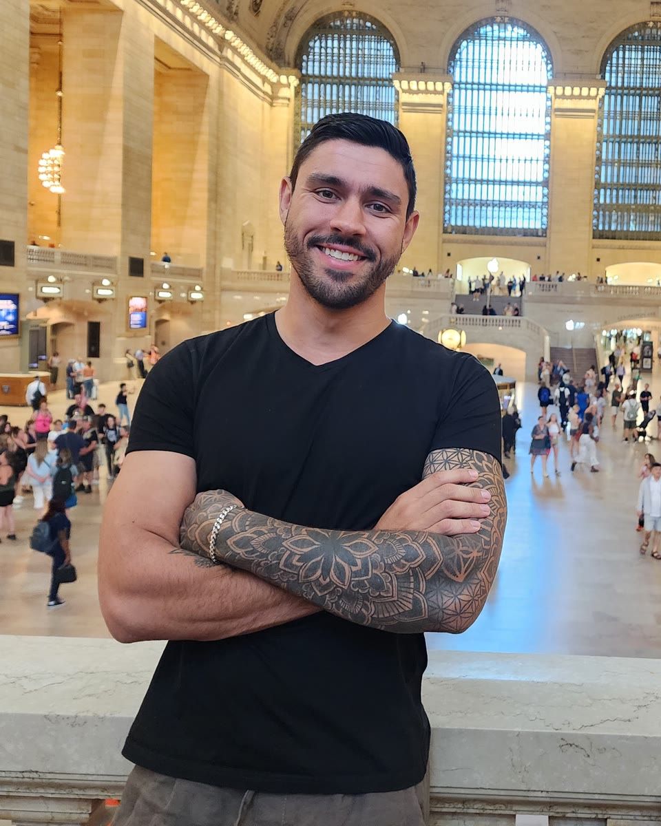 Devin smiling, arms crossed, in Grand Central Terminal, New York, June 2025